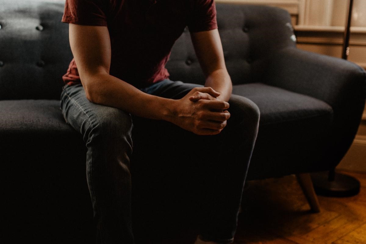 Person on Couch clasping hands